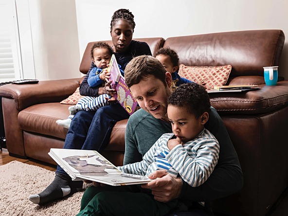 a father reading a storybook to his son